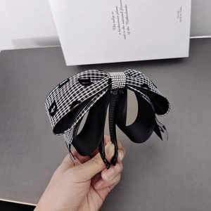 Detailed shot of the rhinestone bow banana clip with elegant black and white plaid pattern