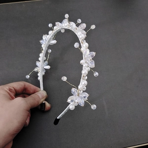 Detail of handcrafted bridal headband with white pearls and crystal flower ornaments