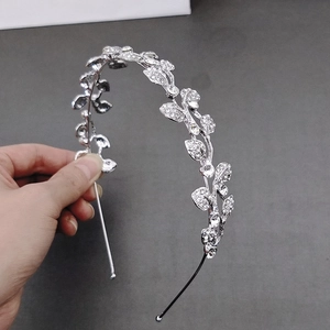 Detailed view of silver leaf headband with inlaid rhinestones and intricate metal finish
