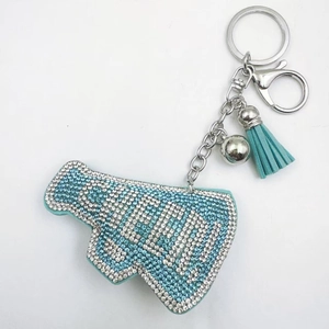 Close-up of sky blue rhinestone megaphone keychain with silver CHEER lettering and tassels