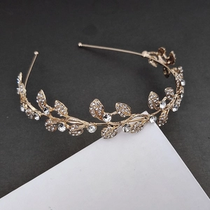 Detailed macro view of golden leaf headband featuring intricate rhinestone vine embellishments