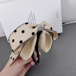 Elegant banana clip featuring a beige floral ribbon bow with sparkling rhinestones