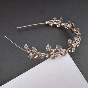 Detail of vintage golden leaf bridal tiara with sparkling rhinestones for weddings