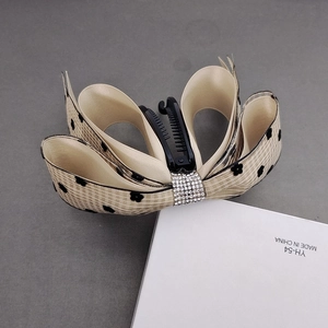 Detail of banana hair clip with mesh bow, black floral print and rhinestone center