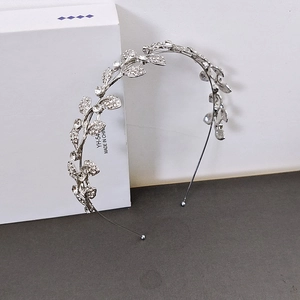 Detailed macro view of silver leaf headband with crystals on white gift box