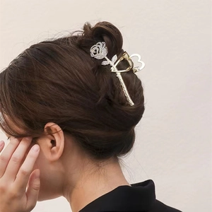 Detailed back view of a gold rose hair claw clip with rhinestones on an elegant updo