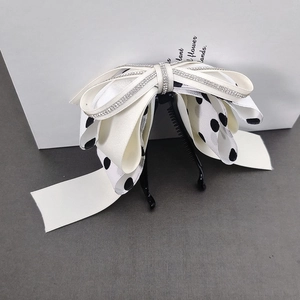 Elegant banana hair clip with large layered ribbon bow and rhinestone trim in cream white