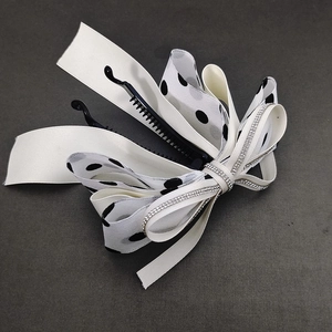 Detailed close-up of cream satin and polka dot chiffon layers on the banana clip