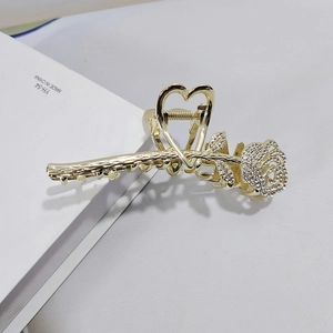 Golden rose hair claw clip with white rhinestones and heart-shaped handle detail