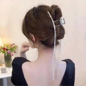 Silver metal hair claw clip with long sparkling tassel on elegant low bun hairstyle