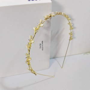 Detail view of cat's eye stone flowers and rhinestones on a gold metal headband