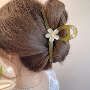 Detail einer großen grün-transparenten Blumen-Haarklammer für elegante Hochsteckfrisuren