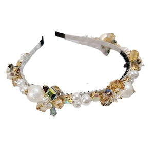 Elegant beaded headband with pearls and champagne crystals on a white background