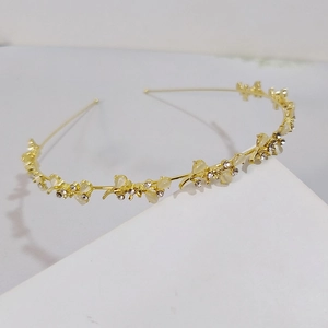 Detail shot of golden bird ornaments with sparkling rhinestones on a slim metal headband