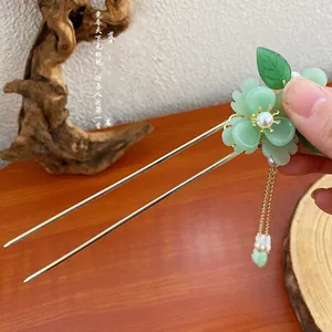Dettaglio della forcina per capelli peonia verde smeraldo con nappe dorate e perle