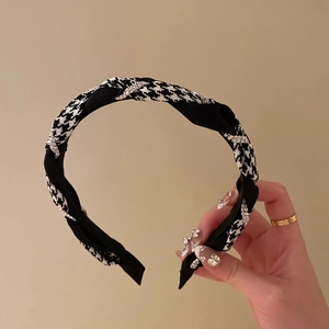 Detail of houndstooth plaid headband with sparkling crystal accents and twisted fabric