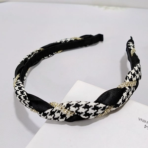 Detail of twisted houndstooth headband with black satin and sparkling golden rhinestones