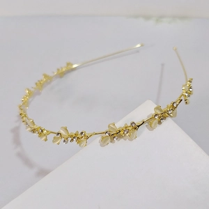 Elegant gold metal headband featuring cat eye stones and sparkling white rhinestones