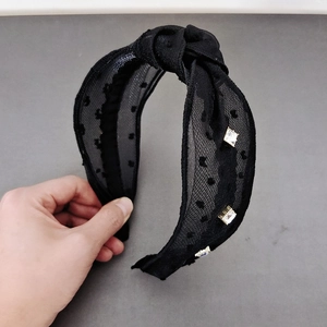 Detailaufnahme des Knoten-Haarreifs mit schwarzem Polka-Dot-Netz und glänzenden Strasssteinen