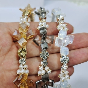 Close-up of three handcrafted crystal headbands with rhinestone and pearl detailing