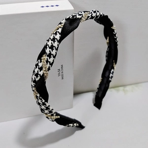 Detail of houndstooth headband featuring interwoven black satin and rhinestone gold cord