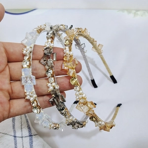 Close-up of three crystal headbands with faceted beads and faux pearls in gold and grey