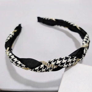 Detail of houndstooth plaid headband with satin twist and rhinestone chain trim
