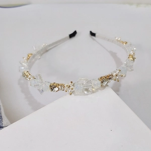 Detail of handcrafted rhinestone headband with crystals and pearls on white frame