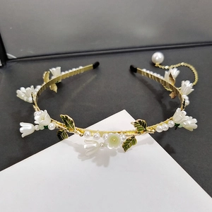 Détails du serre-tête muguet avec perles blanches et pompon doré élégant