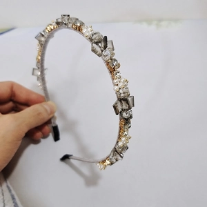 Macro shot of handcrafted crystal headband with gray rhinestones and white pearls detail
