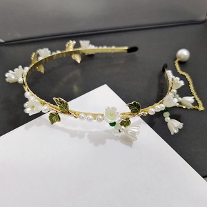 Détail du serre-tête muguet en métal doré avec perles blanches et feuilles vertes