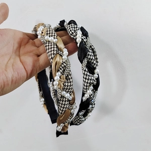 Detailed view of woven houndstooth headbands with sparkling rhinestones and white pearls