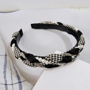 Detailed view of houndstooth braided headband with white pearls and sparkling rhinestones