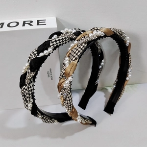 Detail of houndstooth braided headbands with pearls and rhinestones on white display
