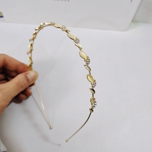 Détail d'un serre-tête feuilles dorées avec pierres œil de chat jaunes et cristaux fins