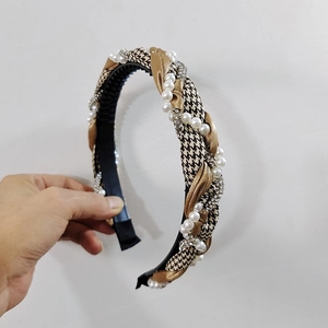 Detail of woven houndstooth headband with pearls and rhinestones on a toothed base