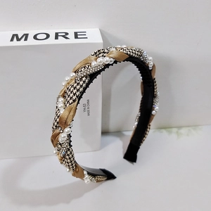 Houndstooth braided headband with rhinestones and pearls on a white display base