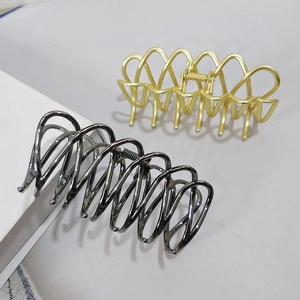 Detail of large metal shark clips in matte gold and gunmetal with mesh hollow design
