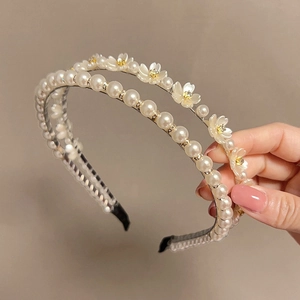 Détail d'un serre-tête double couche avec fleurs en résine et rangées de perles