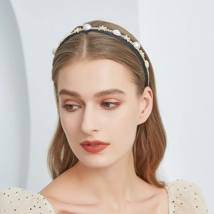 Detailed view of pearl headband featuring gold starfish and shell accents on black band