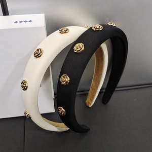 Detail of padded headbands in black and cream with decorative golden metal roses