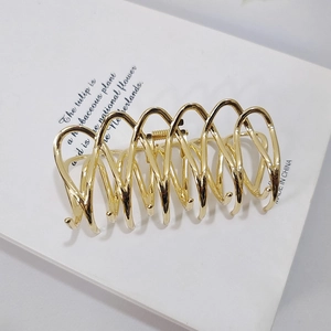Elegant gold metal hair claw clip with a large spiral hollow design for thick hair styling