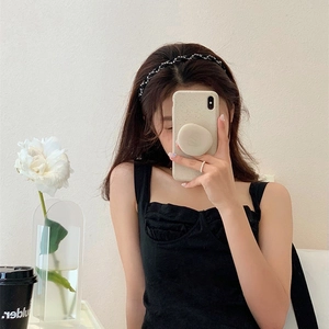 Detailed view of a black twisted headband with sparkling rhinestones worn by a model