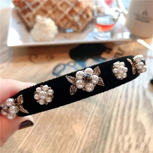 Détail d'un serre-tête en velours avec fleurs de camélia en perles et feuilles d'or
