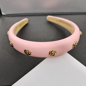 Pink wide leather headband featuring five gold metal camellia flowers and velvet lining