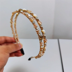 Macro detail of elegant double-layered gold headband with sparkling crystals and pearls