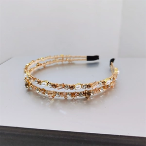 Detail of double-layer gold headband featuring champagne crystals and white pearls