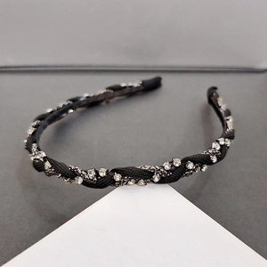 Detail of French black braided headband with rows of sparkling rhinestones and chains
