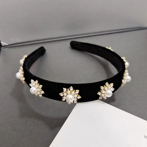 Detail view of the elegant black velvet headband featuring ornate pearl and rhinestone stars