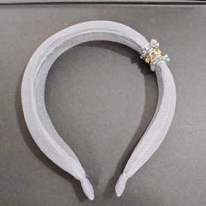 Détail d'un serre-tête élégant en organza avec cristaux et chaîne dorée chic